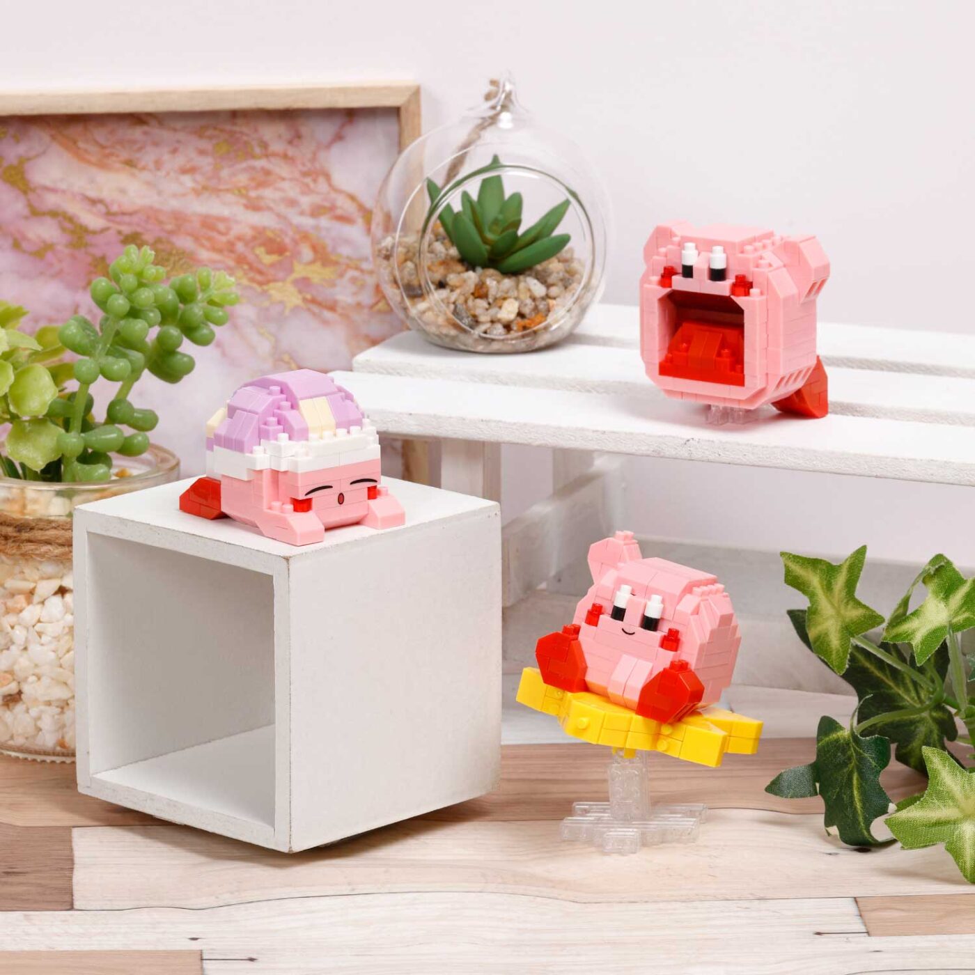 Several Kirby nanoblock models arranged on a white shelf in a styled room